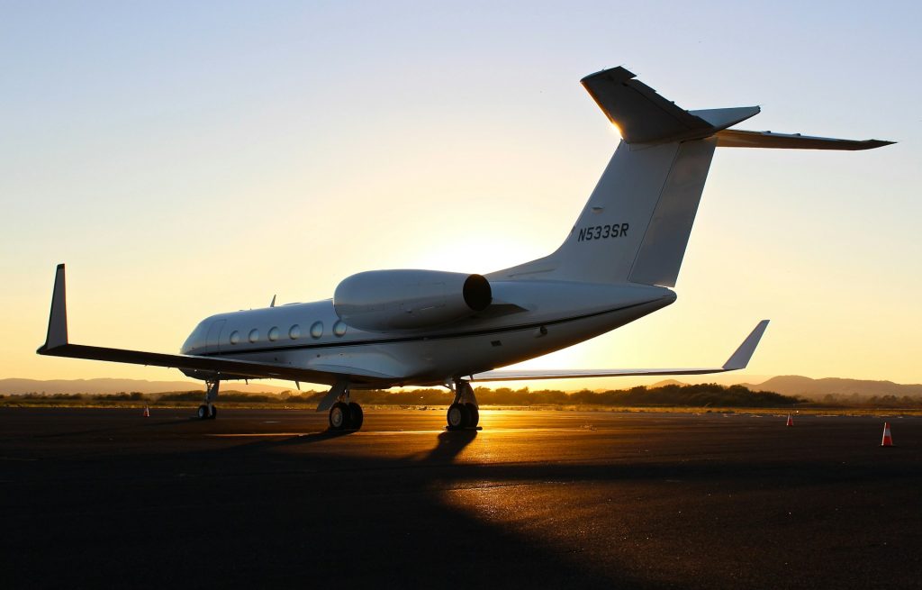 Real white private jet on the airport tarmac at golden hour, photographed by Chris Leipelt